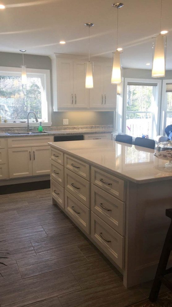 Example of a mid-sized transitional u-shaped porcelain tile and gray floor eat-in kitchen design with an undermount sink, recessed-panel cabinets, white cabinets, quartz countertops, stainless steel appliances, an island and white countertops