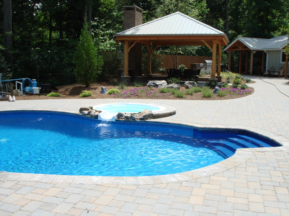 Inspiration for a mid-sized rustic backyard stone and custom-shaped natural pool remodel in Raleigh