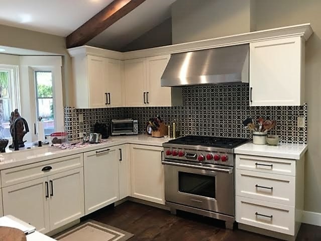 Mid-sized transitional u-shaped dark wood floor and brown floor eat-in kitchen photo in San Francisco with a single-bowl sink, shaker cabinets, white cabinets, quartz countertops, black backsplash, stainless steel appliances and white countertops