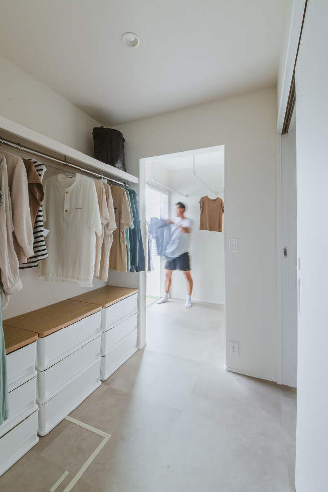 Imagen de armario vestidor unisex de estilo de casa de campo con suelo gris y papel pintado