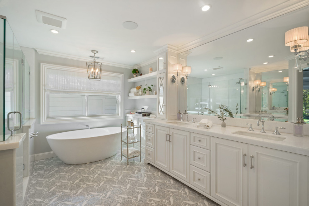 Photo of a large classic ensuite bathroom in San Francisco with raised-panel cabinets, white cabinets, a freestanding bath, a corner shower, grey walls, mosaic tile flooring, a submerged sink, marble worktops, grey floors, a hinged door, white worktops and a built in vanity unit.