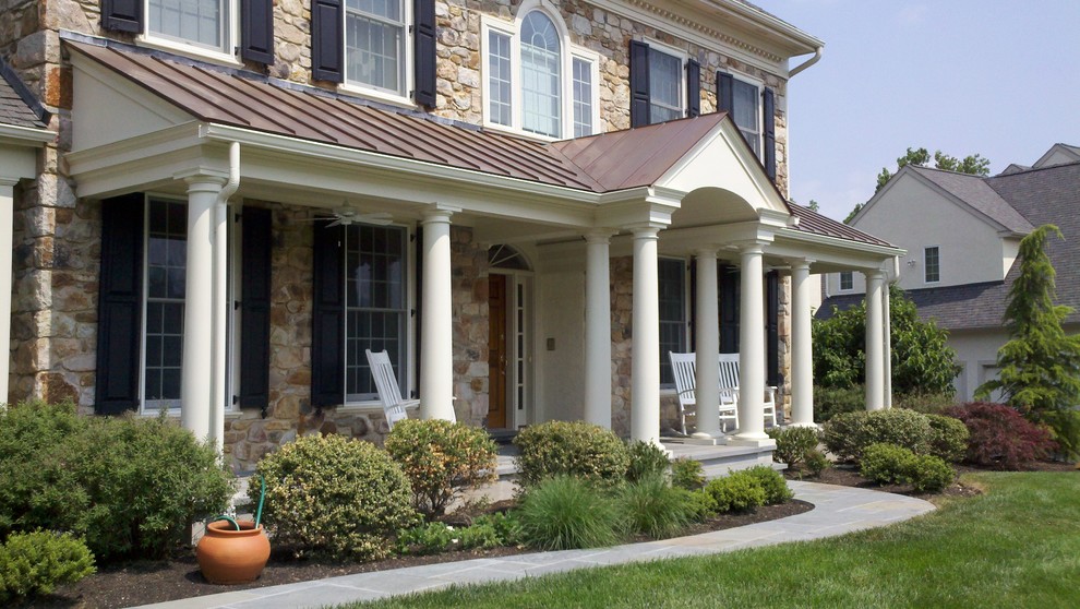 Photo of a large country front yard verandah in Philadelphia with natural stone pavers and a roof extension.