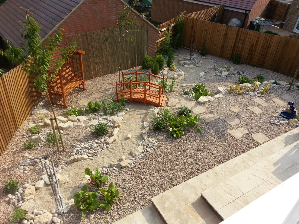Inspiration for a mid-sized asian backyard full sun garden in Oxfordshire with with rock feature and river rock.
