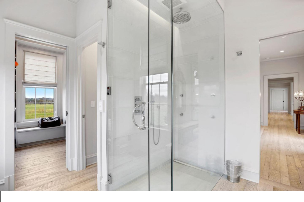 Walk-in shower - mid-sized transitional master light wood floor and double-sink walk-in shower idea in DC Metro with shaker cabinets, white cabinets, a one-piece toilet, gray walls, quartz countertops, a hinged shower door, white countertops and a built-in vanity