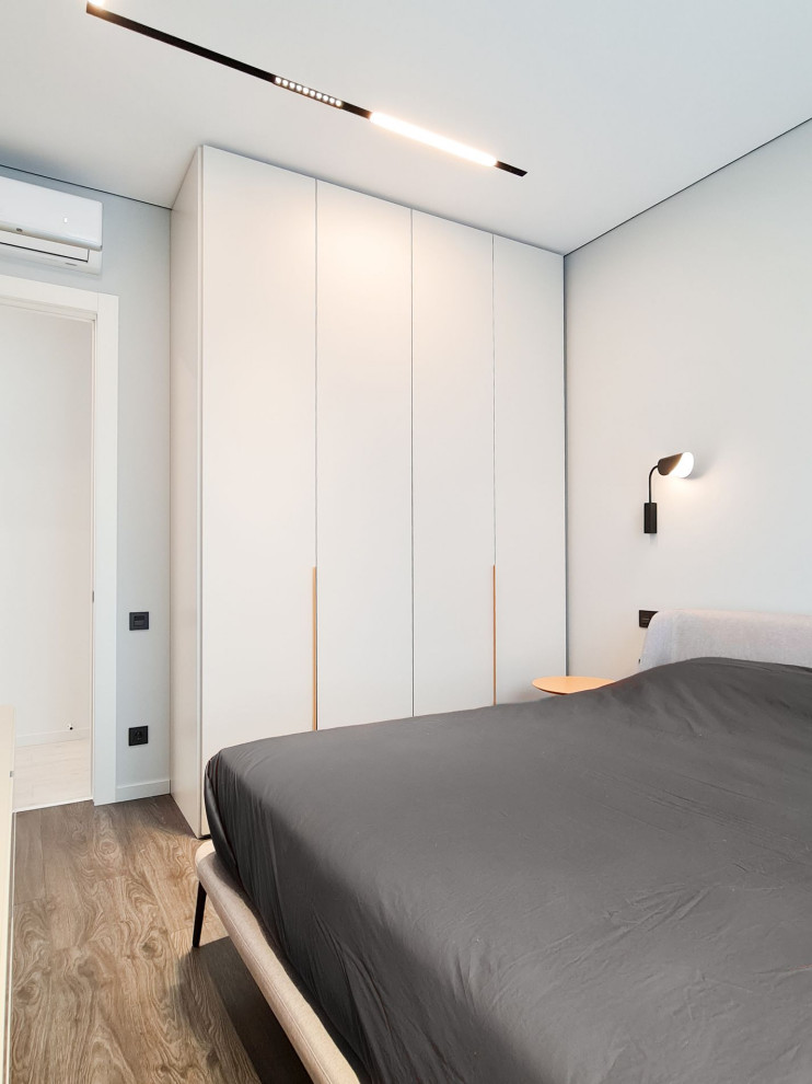 Kleines Modernes Hauptschlafzimmer mit weißer Wandfarbe und Vinylboden in Moskau