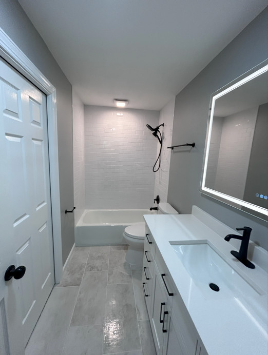 Bathroom - mid-sized kids' white tile and porcelain tile ceramic tile, gray floor and single-sink bathroom idea in Other with shaker cabinets, white cabinets, a two-piece toilet, gray walls, an underm