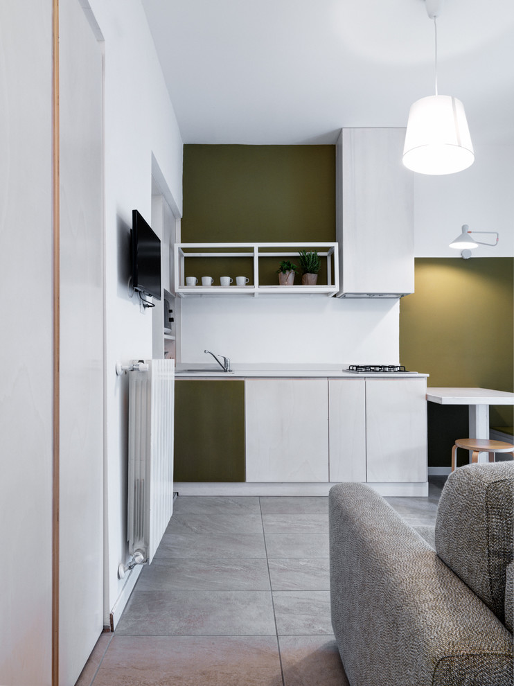 This is an example of a small contemporary single-wall eat-in kitchen in Other with flat-panel cabinets, white cabinets, white splashback, no island, grey floor, white benchtop and a drop-in sink.
