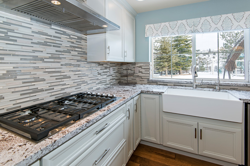 Enclosed kitchen - large transitional medium tone wood floor enclosed kitchen idea with a farmhouse sink, recessed-panel cabinets, white cabinets, granite countertops, multicolored backsplash, matchstick tile backsplash, stainless steel appliances and an island