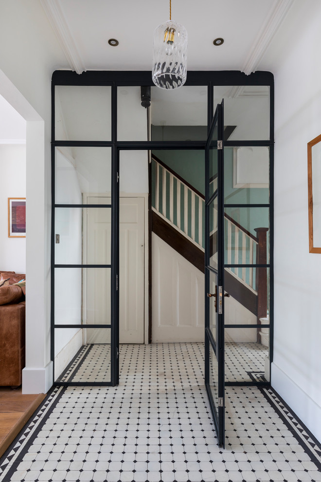 This is an example of a contemporary hallway in London with white walls and white floor.