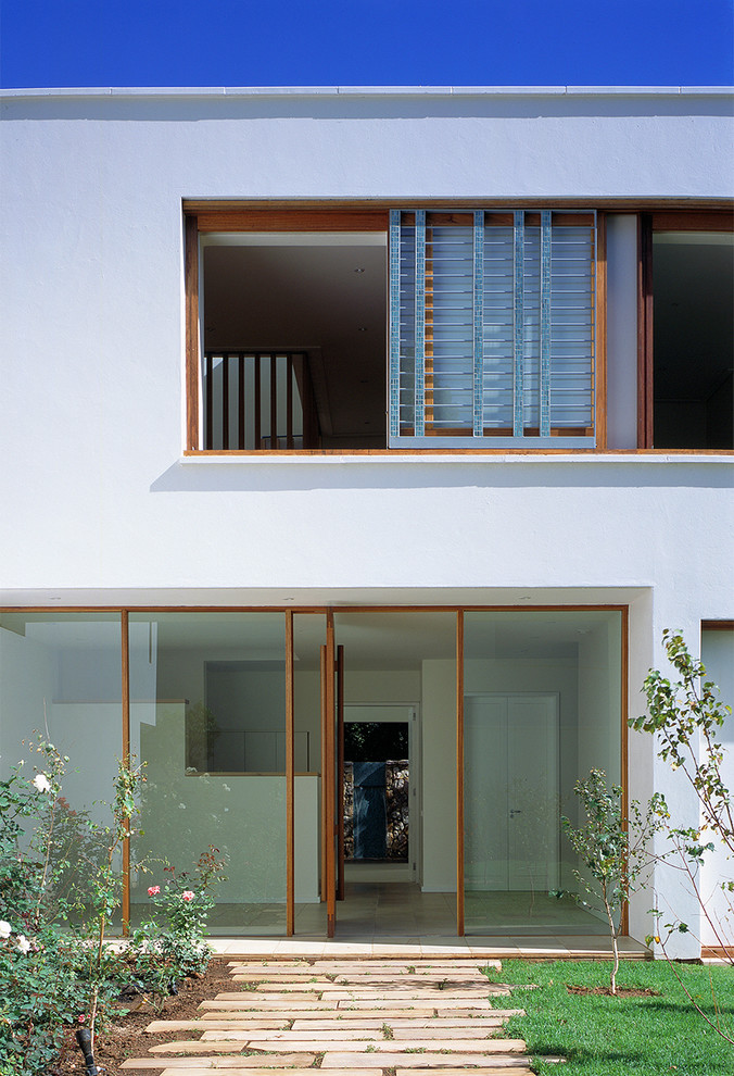 Inspiration for a contemporary two-storey white exterior in Other with a flat roof.