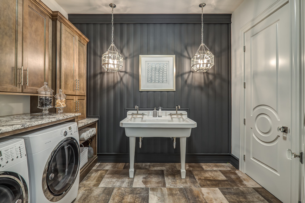 Design ideas for a large traditional single-wall dedicated laundry room in Other with an utility sink, granite benchtops, grey walls, a side-by-side washer and dryer, recessed-panel cabinets, dark wood cabinets and brown floor.