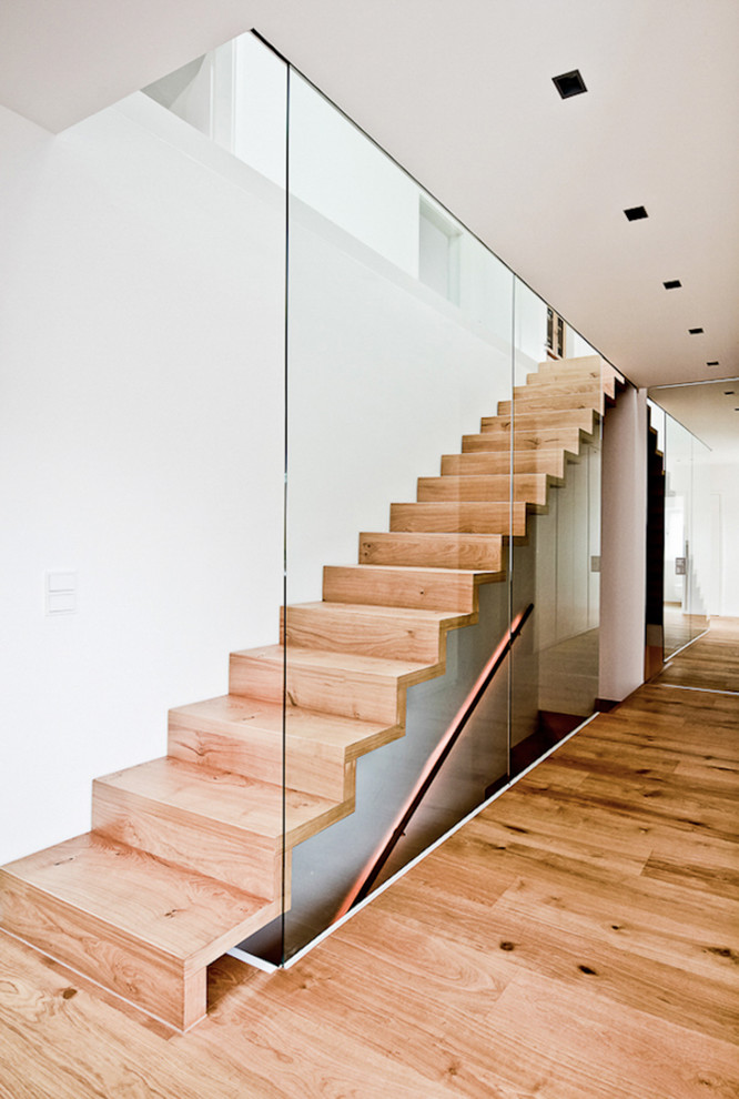 Mid-sized contemporary wood straight staircase in Munich with wood risers.