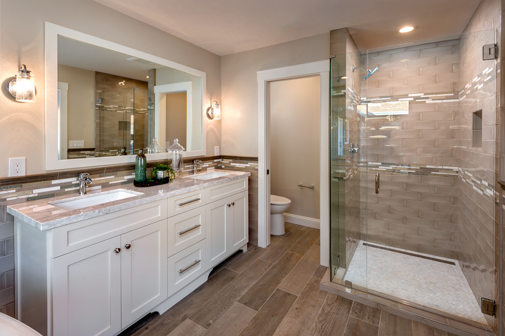 Inspiration for a mid-sized contemporary master bathroom in San Francisco with shaker cabinets, white cabinets, marble benchtops, a freestanding tub, a corner shower, ceramic tile, beige walls, porcelain floors, an undermount sink, beige floor and a hinged shower door.