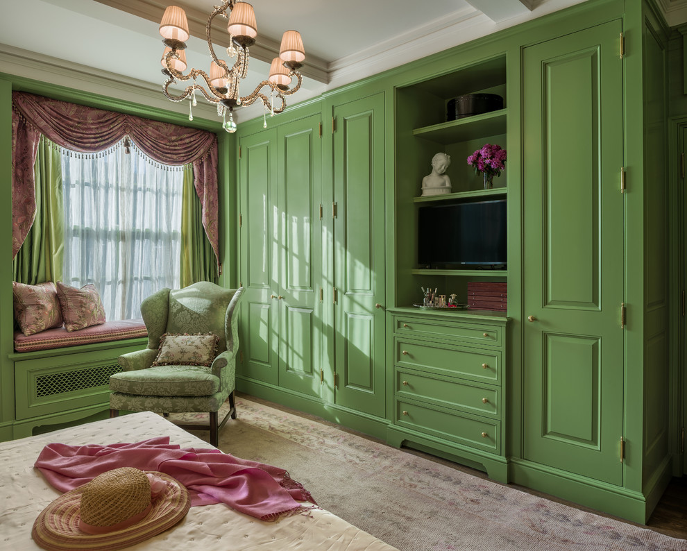 This is an example of a mid-sized traditional master bedroom in New York with green walls, medium hardwood floors and brown floor.