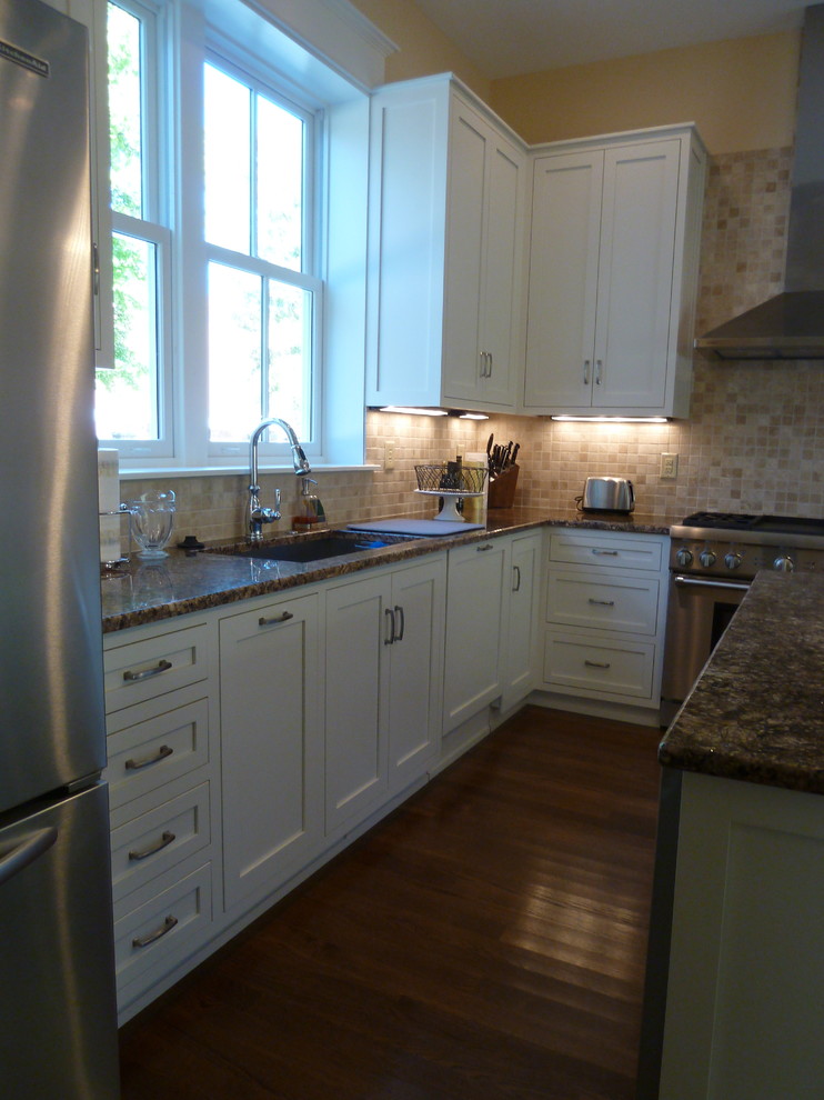 Eat-in kitchen - mid-sized transitional l-shaped medium tone wood floor eat-in kitchen idea in Indianapolis with an undermount sink, shaker cabinets, white cabinets, granite countertops, beige backsplash, stone tile backsplash, stainless steel appliances and an island
