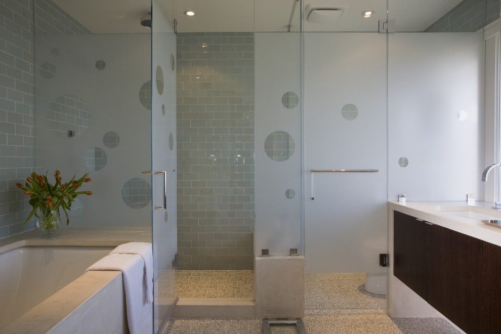 This is an example of a contemporary bathroom in DC Metro with an undermount tub and blue tile.