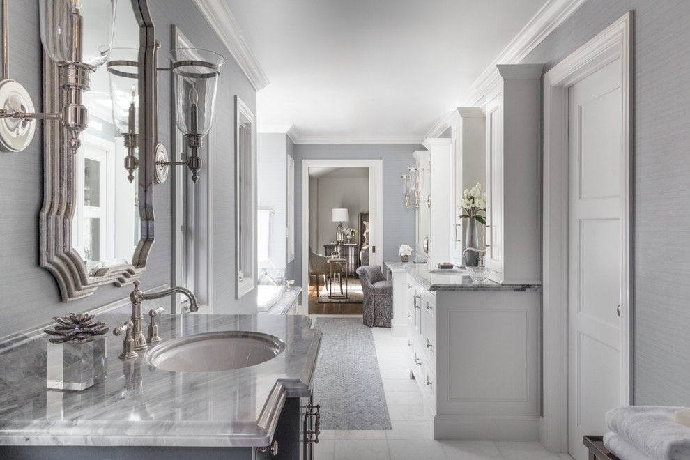 Photo of a mid-sized traditional master bathroom in San Francisco with recessed-panel cabinets, white cabinets, grey walls, an undermount sink, white floor, grey benchtops, a drop-in tub, gray tile, porcelain tile, marble benchtops and porcelain floors.