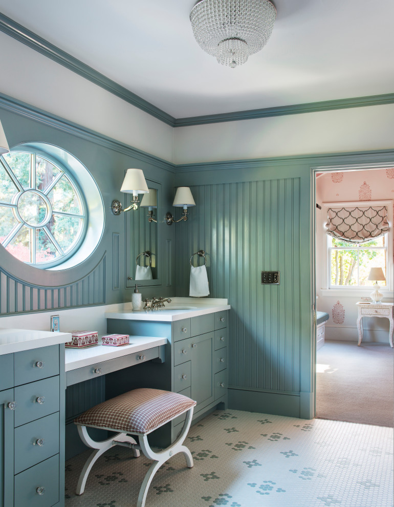 Cette image montre une salle de bain rustique avec un placard à porte shaker, des portes de placard bleues, un mur bleu, un sol en carrelage de terre cuite, un lavabo encastré, un sol multicolore, un plan de toilette blanc, meuble double vasque, meuble-lavabo encastré et boiseries.
