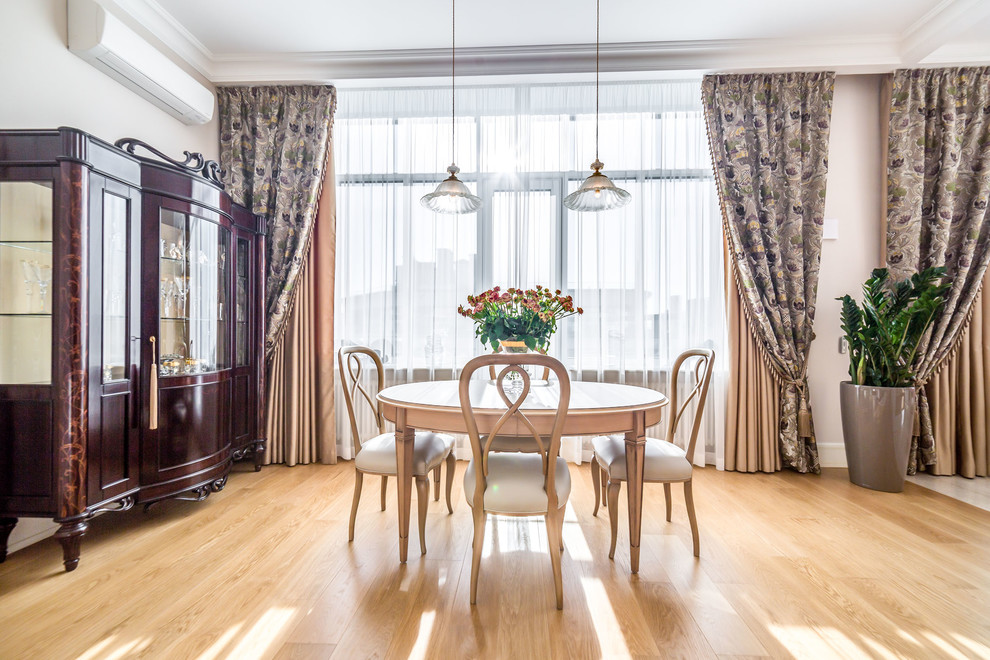 Large traditional open plan dining in Saint Petersburg with light hardwood floors, no fireplace and beige walls.