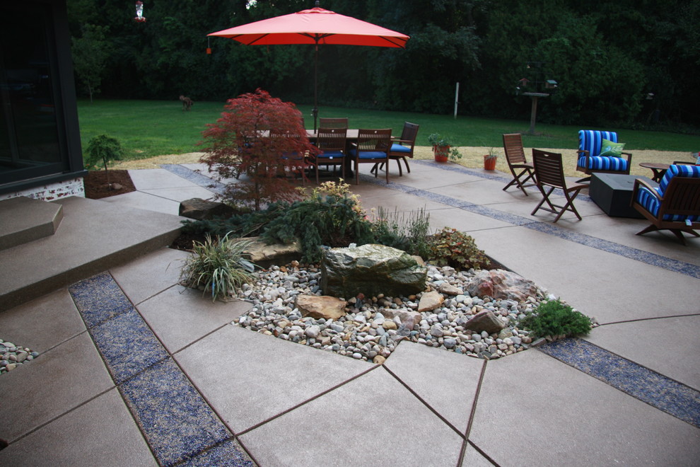 Design ideas for a large contemporary backyard patio in Indianapolis with stamped concrete and no cover.