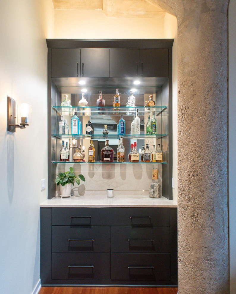 Modelo de bar en casa lineal industrial pequeño sin pila con puertas de armario azules, encimera de cuarcita, salpicadero beige, suelo marrón y encimeras beige