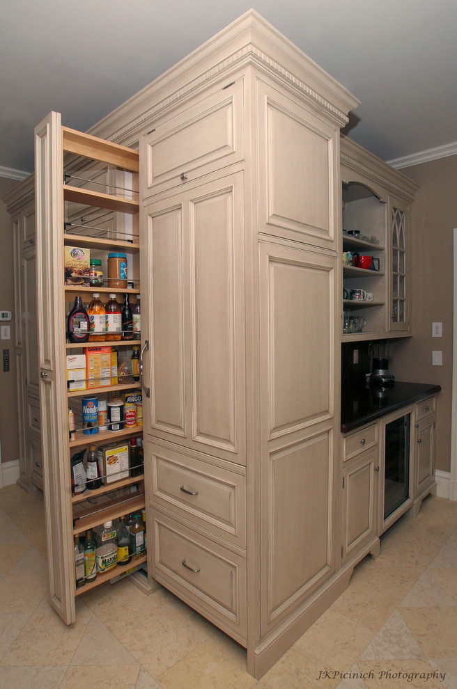 This is an example of a traditional kitchen in Boston with raised-panel cabinets and beige cabinets.