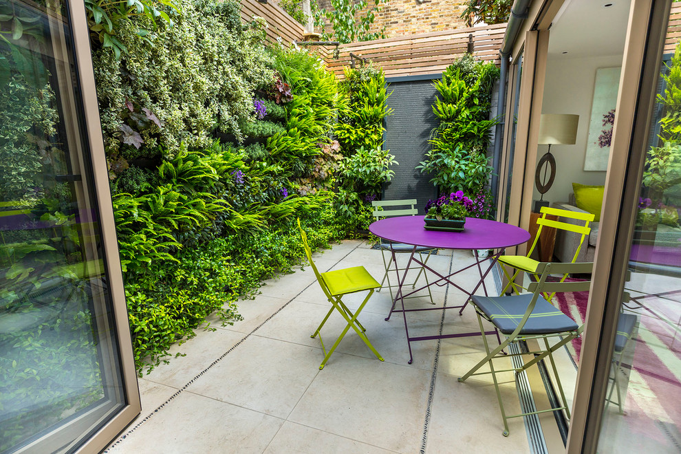 Design ideas for a small contemporary backyard partial sun garden for summer in London with a vertical garden and natural stone pavers.