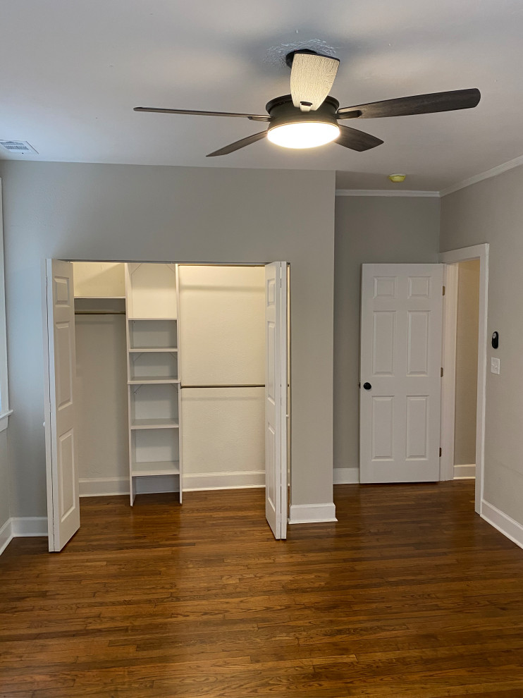 Photo of a mid-sized scandinavian gender-neutral storage and wardrobe in Atlanta with medium hardwood floors, brown floor and wood.