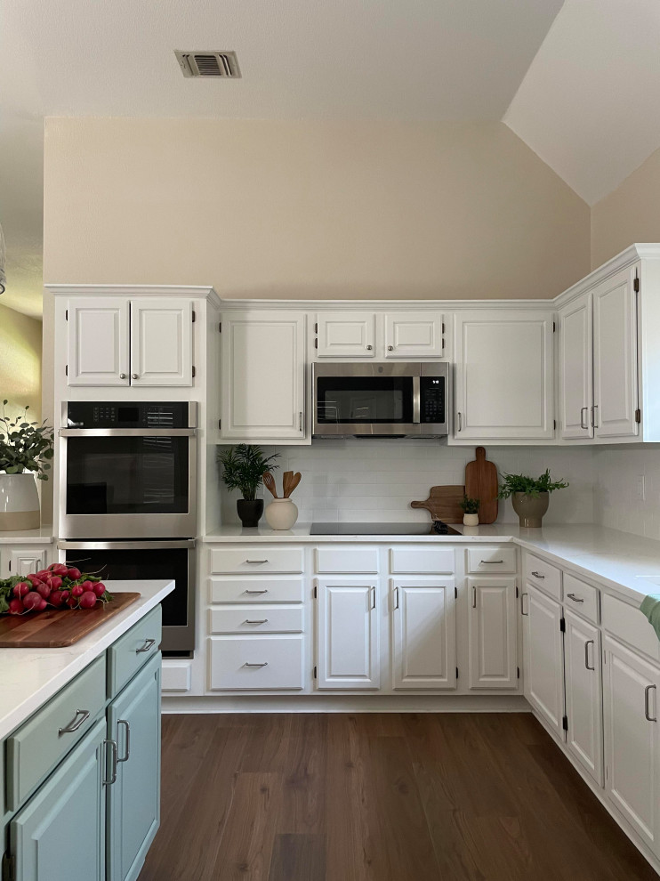 Inspiration for a l-shaped kitchen remodel with a single-bowl sink, white cabinets, white backsplash, subway tile backsplash, white countertops, quartz countertops, stainless steel appliances and an island