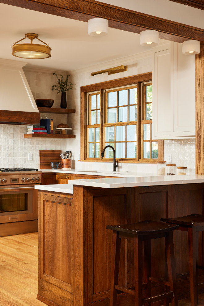 Example of a transitional light wood floor eat-in kitchen design in Minneapolis with an undermount sink, recessed-panel cabinets, quartzite countertops, white backsplash, stainless steel appliances and white countertops