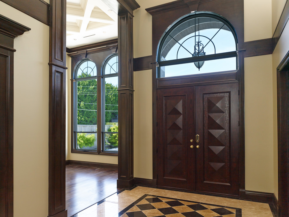 Inspiration for a traditional foyer in Vancouver with a double front door and a dark wood front door.