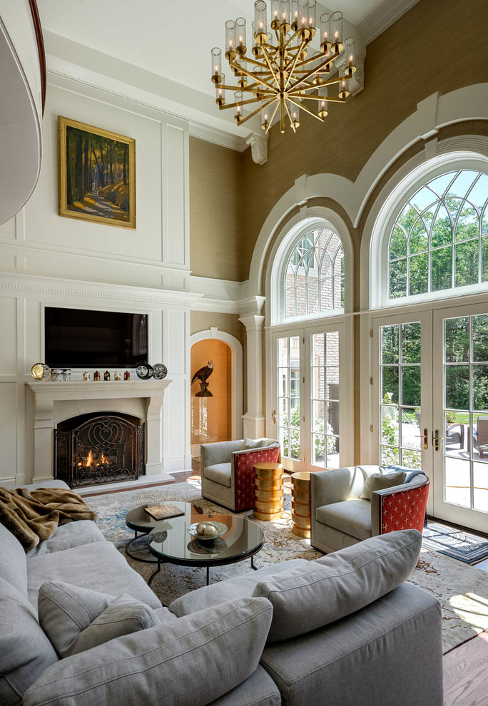 Inspiration for a large traditional formal open concept living room in Boston with green walls, medium hardwood floors, a standard fireplace, a wood fireplace surround, a wall-mounted tv and brown floor.
