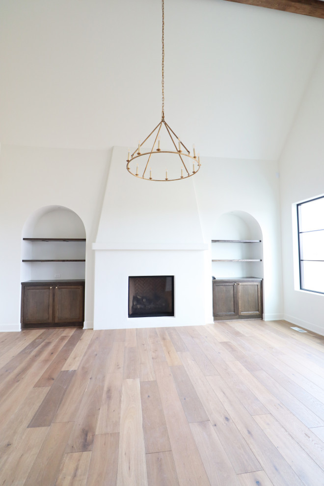 Источник вдохновения для домашнего уюта: отдельная столовая в средиземноморском стиле с белыми стенами, светлым паркетным полом, стандартным камином и сводчатым потолком