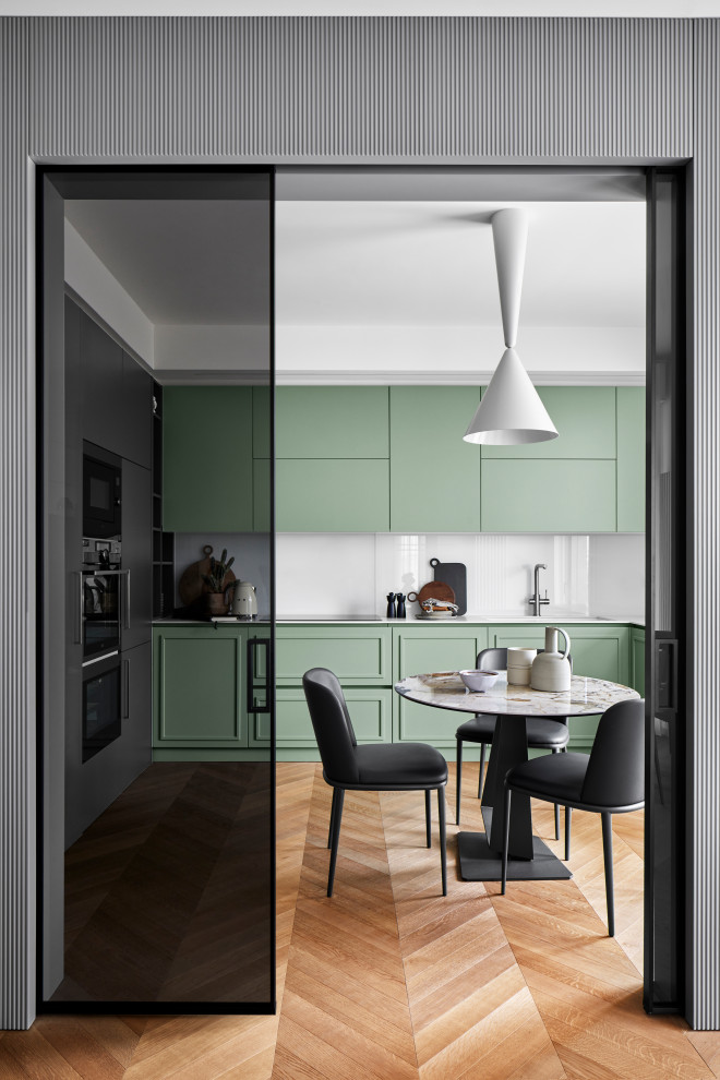 Cette photo montre une cuisine tendance avec des portes de placards vertess, un plan de travail en surface solide, une crédence blanche, une crédence en feuille de verre et un plan de travail blanc.