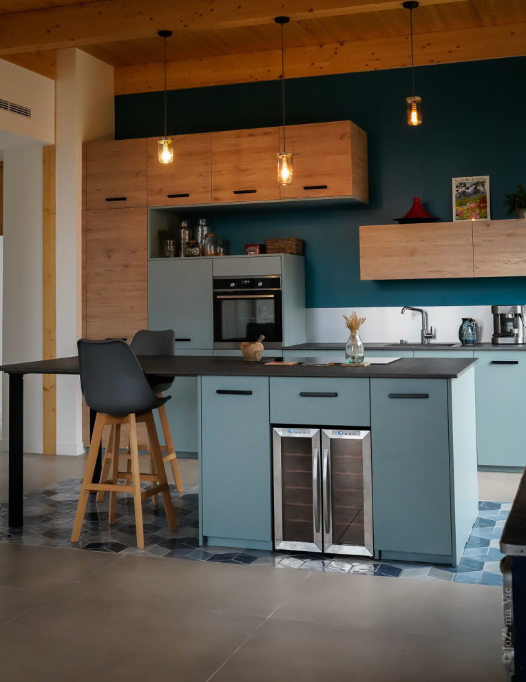 Inspiration pour une cuisine ouverte parallèle minimaliste de taille moyenne avec un évier intégré, des portes de placard bleues, une crédence métallisée, un électroménager en acier inoxydable, un sol en carrelage de céramique, îlot, un sol bleu, un plan de travail gris et poutres apparentes.