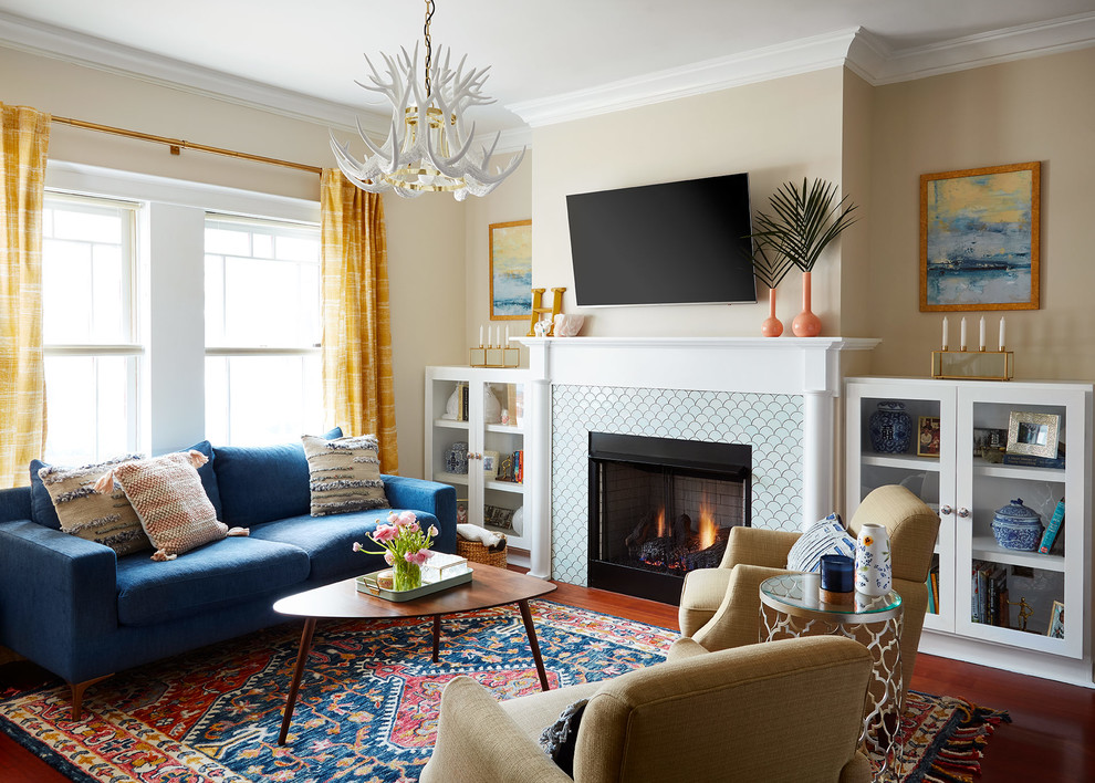Inspiration for an eclectic living room in Chicago with beige walls, medium hardwood floors, a standard fireplace, a tile fireplace surround, a wall-mounted tv and red floor.