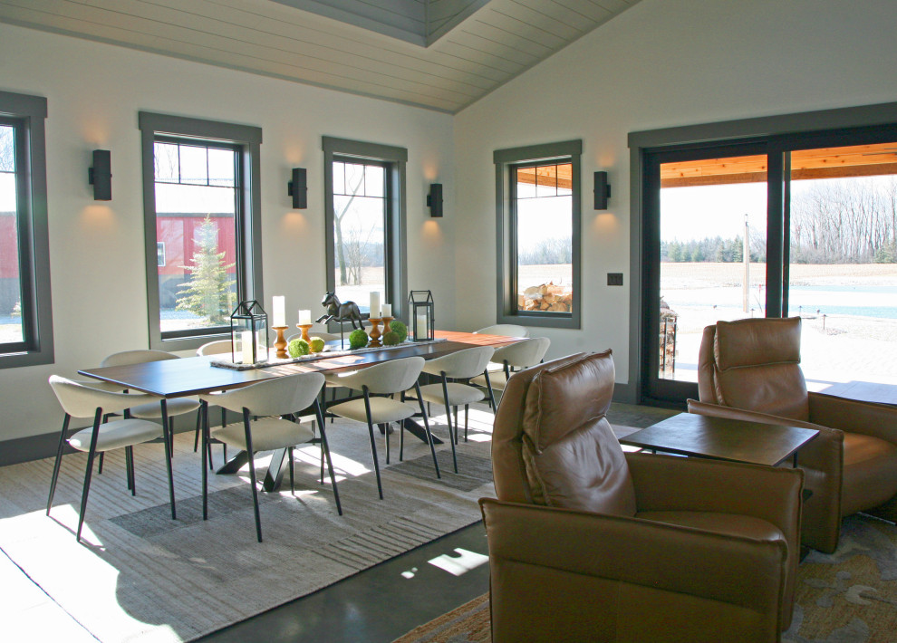 Exemple d'une salle à manger ouverte sur le salon montagne en bois de taille moyenne avec sol en béton ciré et un plafond voûté.