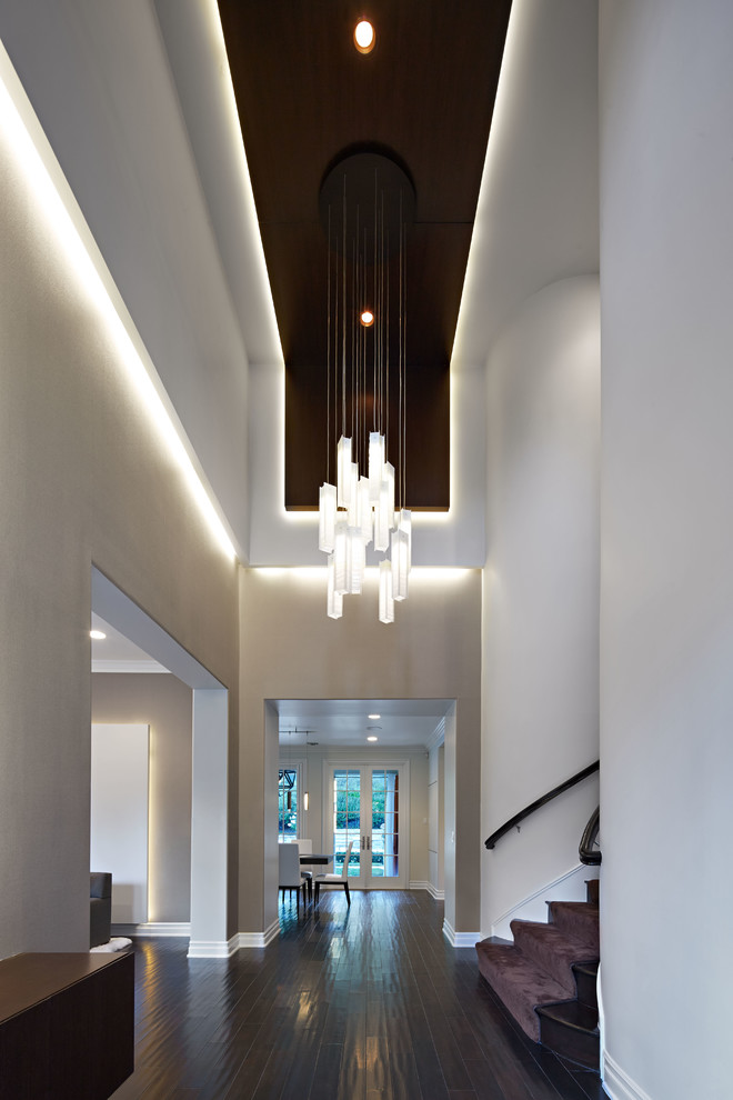 This is an example of a large contemporary entry hall in Los Angeles with beige walls and dark hardwood floors.