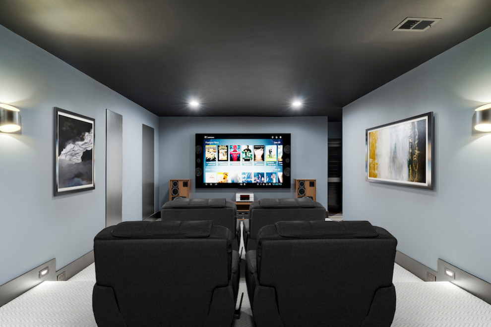 Пример оригинального дизайна: изолированный домашний кинотеатр среднего размера в стиле модернизм с синими стенами, ковровым покрытием и телевизором на стене