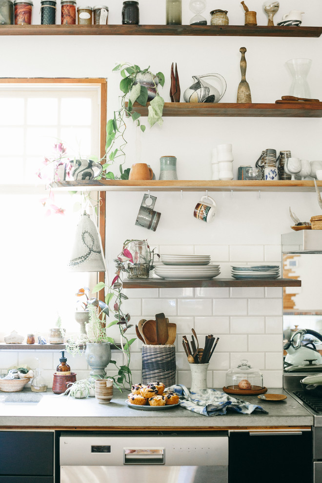 Kitchen pantry - mid-sized eclectic l-shaped medium tone wood floor kitchen pantry idea in Portland with open cabinets, concrete countertops, metallic backsplash, mirror backsplash and stainless steel appliances