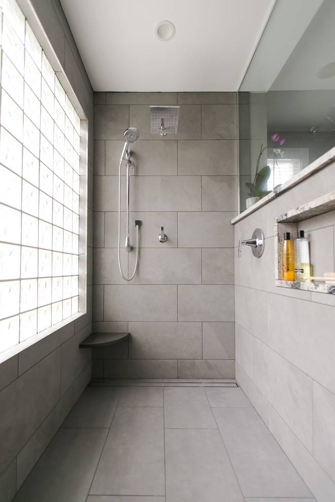 Design ideas for a mid-sized modern master bathroom in Indianapolis with recessed-panel cabinets, white cabinets, a curbless shower, a one-piece toilet, gray tile, ceramic tile, grey walls, ceramic floors, a vessel sink, granite benchtops, grey floor, an open shower and grey benchtops.