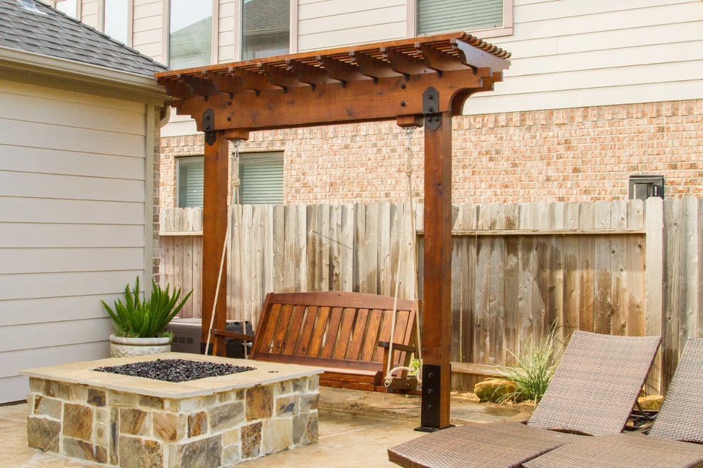 Large elegant backyard stone patio photo in Houston with a fire pit and a pergola