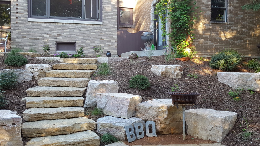 Photo of a small country backyard patio in Milwaukee with an outdoor kitchen, natural stone pavers and no cover.