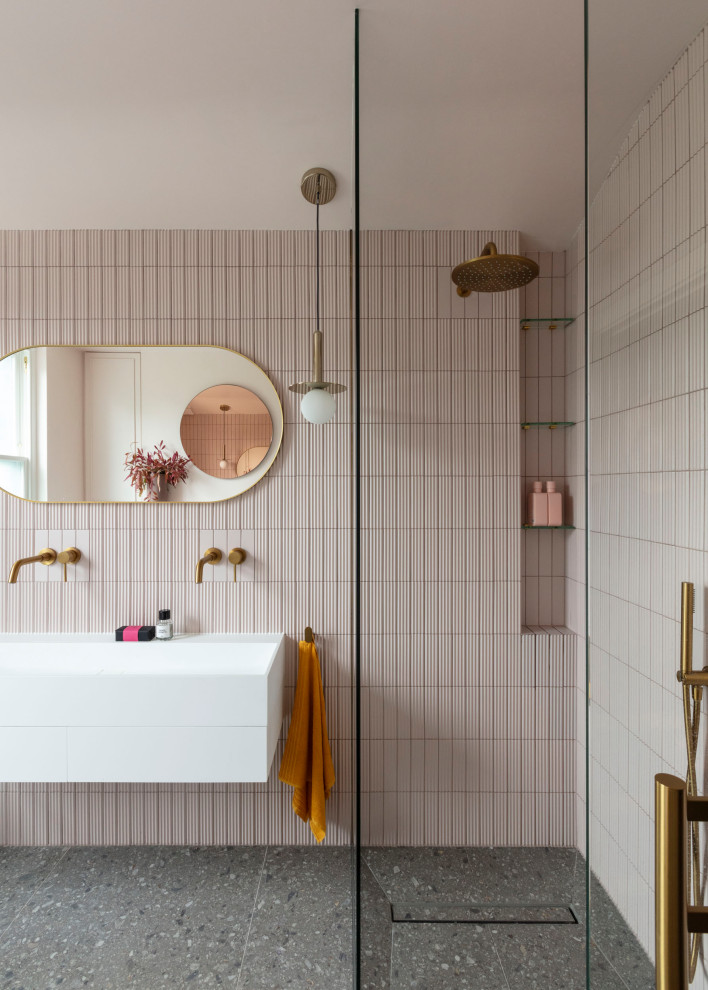 This is an example of a medium sized contemporary grey and pink family bathroom in London with flat-panel cabinets, white cabinets, pink tiles, ceramic tiles, ceramic flooring, grey floors, an open shower, a chimney breast, double sinks, a floating vanity unit, a vaulted ceiling, a built-in shower and a trough sink.