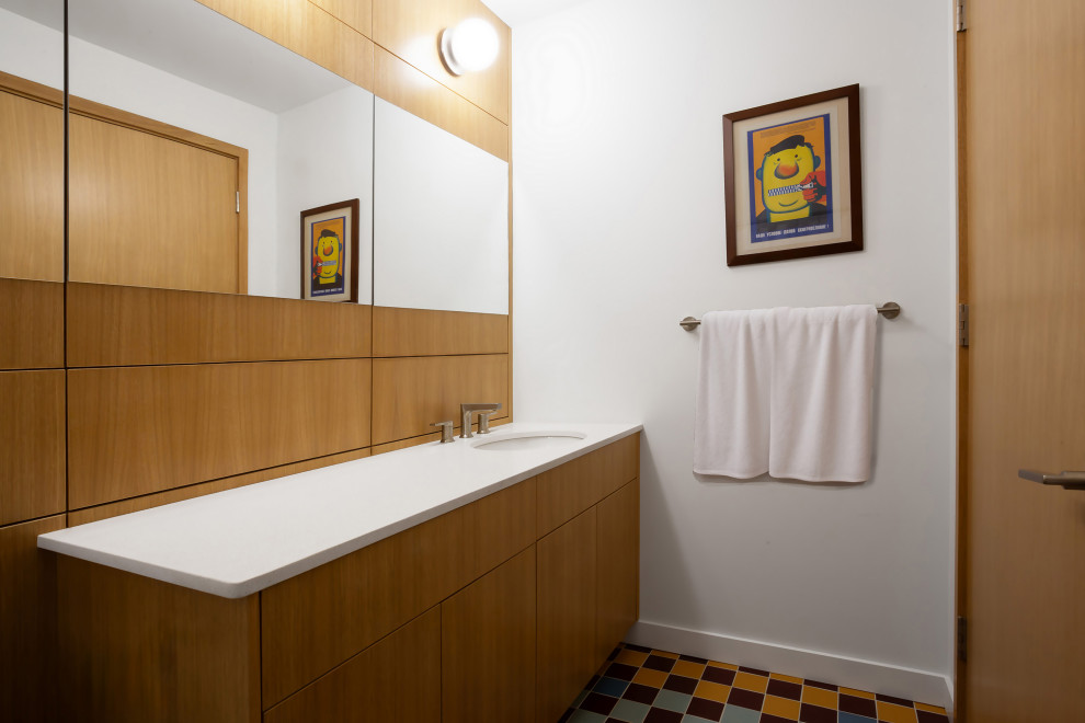 Идея дизайна: детская ванная комната в стиле модернизм с плоскими фасадами, фасадами цвета дерева среднего тона, угловой ванной, душем над ванной, унитазом-моноблоком, белыми стенами, полом из керамогранита, накладной раковиной, столешницей из гранита, разноцветным полом, шторкой для ванной, белой столешницей, тумбой под одну раковину и встроенной тумбой