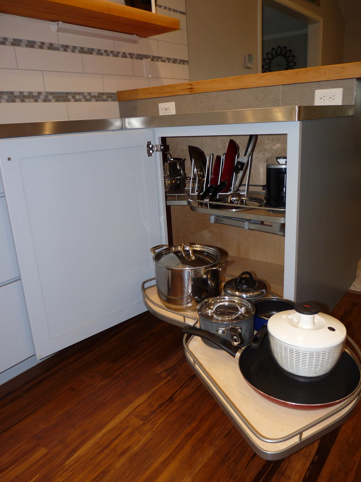 Bamboo floor kitchen photo with gray cabinets, white backsplash, ceramic backsplash and white appliances