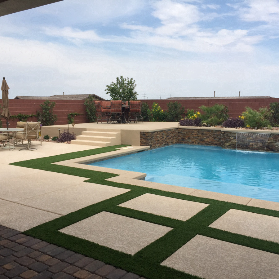 Photo of a mid-sized traditional backyard rectangular lap pool in Las Vegas with a water feature and concrete pavers.