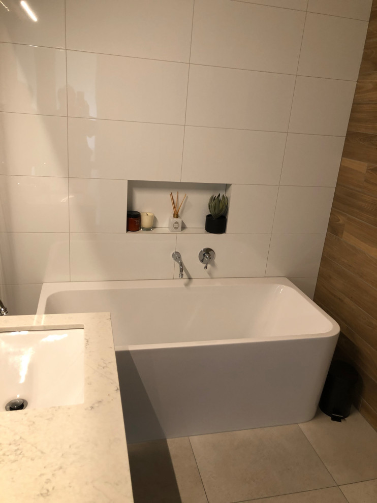 Photo of a small contemporary kids bathroom in Other with flat-panel cabinets, light wood cabinets, a freestanding tub, an open shower, white tile, ceramic tile, white walls, ceramic floors, an undermount sink, solid surface benchtops, grey floor, an open shower, white benchtops, a niche, a single vanity and a floating vanity.