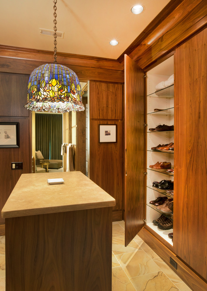 Large contemporary men's dressing room in Omaha with flat-panel cabinets, brown cabinets and limestone floors.