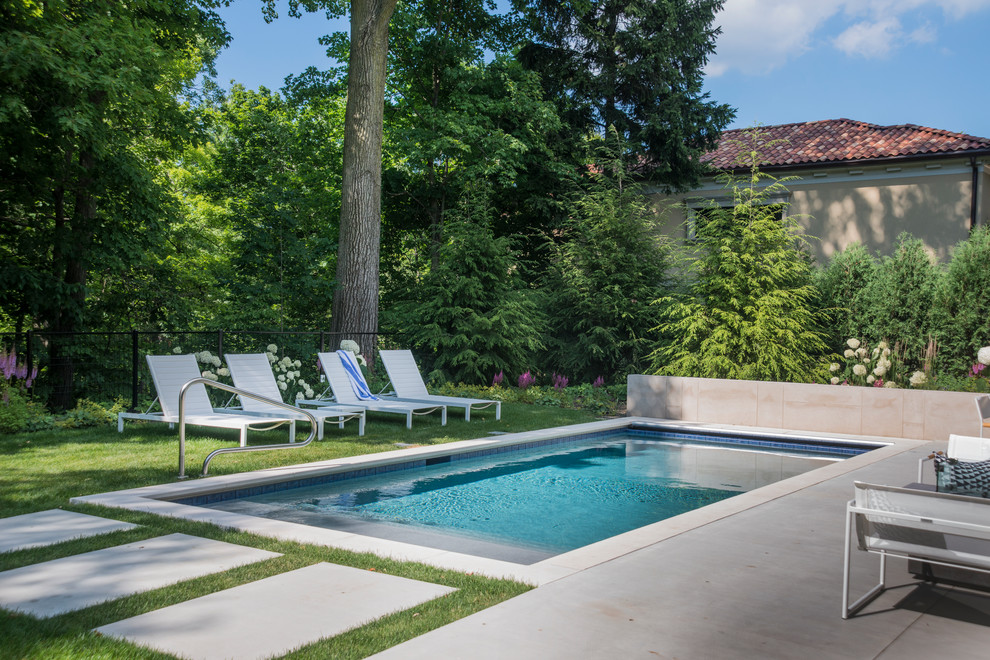 Photo of a small modern backyard rectangular lap pool in Chicago with natural stone pavers.